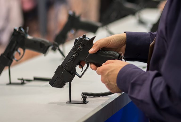 A visitor tests out a pistol on display in a weapons convention
